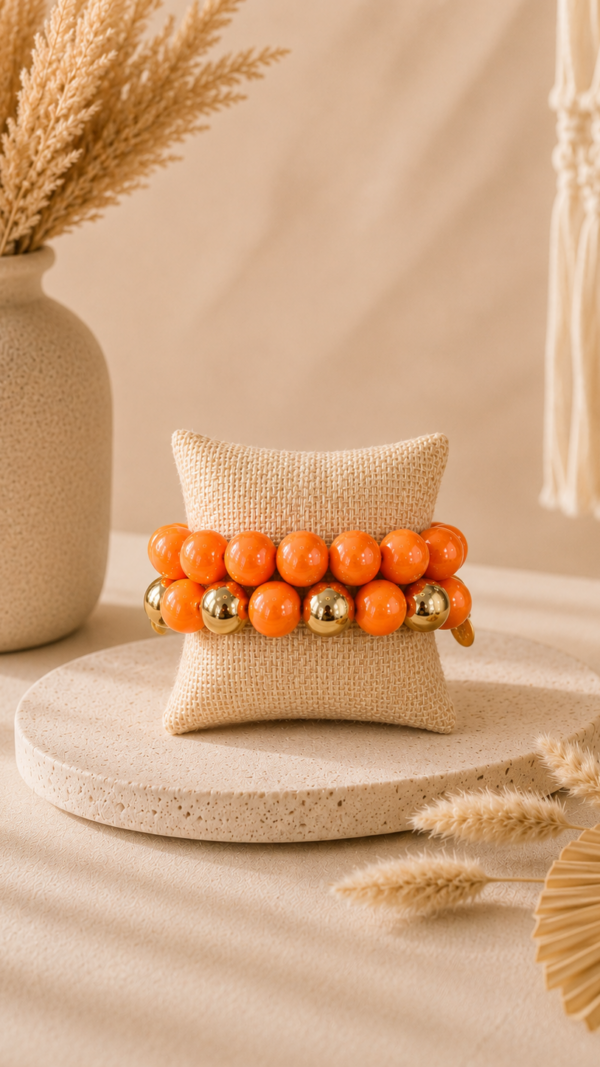 Oranje parelarmband met gouden accenten